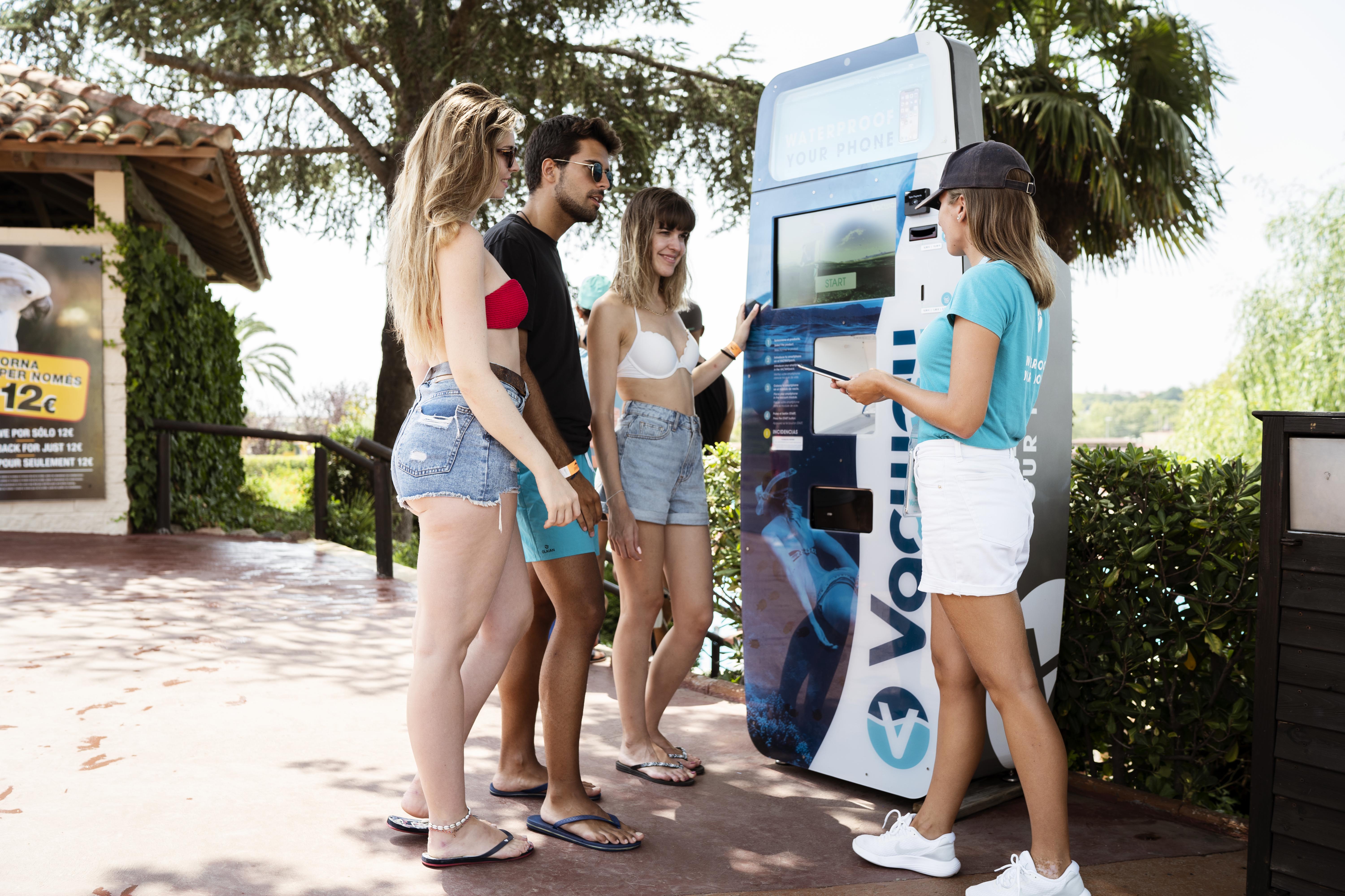 Imatge d'un grup de joves davant una màquina de Vacway en un parc aquàtic.