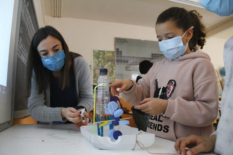 La professora Núria Garrido fent un experment amb una nena de 4t de l'escola Mestre Morera.