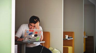 Noi treballant davant d'un ordinador estressat