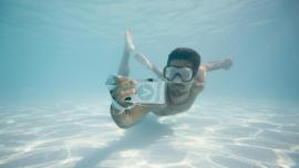 Imatge d'un noi submergit amb un mòbil i la funda Vacway
