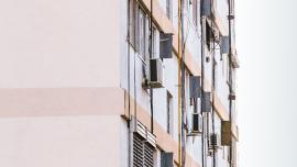 Imatge d'un bloc de pisos amb aparells d'aire condicionat a la façana.