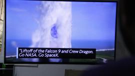 Escorç d'una persona mirant l'enlairament del Crew Dragon