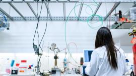 Una noia d'esquenes treballant en un laboratori.