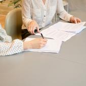 detall de dues persones signant un contracte